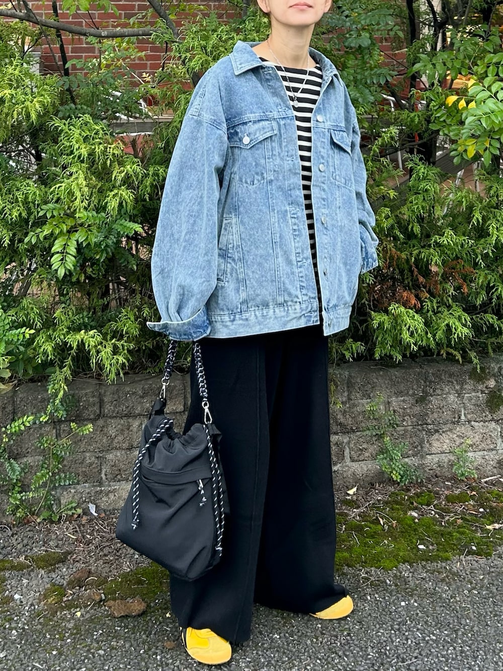 ブルー系のデニムジャケット、ブラック系のTシャツ/カットソー、ブラック系のその他パンツを着用したレディースの秋コーディネートの2枚目の写真