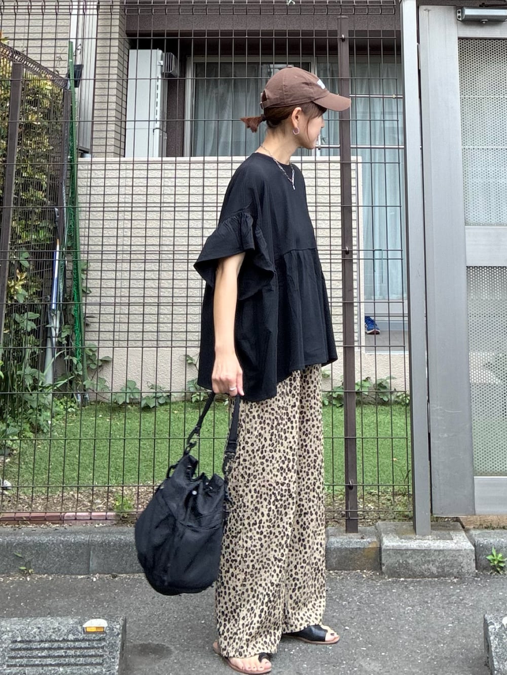 ブラック系のTシャツ/カットソー、ベージュ系のスウェットパンツ、ブラック系のショルダーバッグを着用したレディースの春コーディネートの5枚目の写真