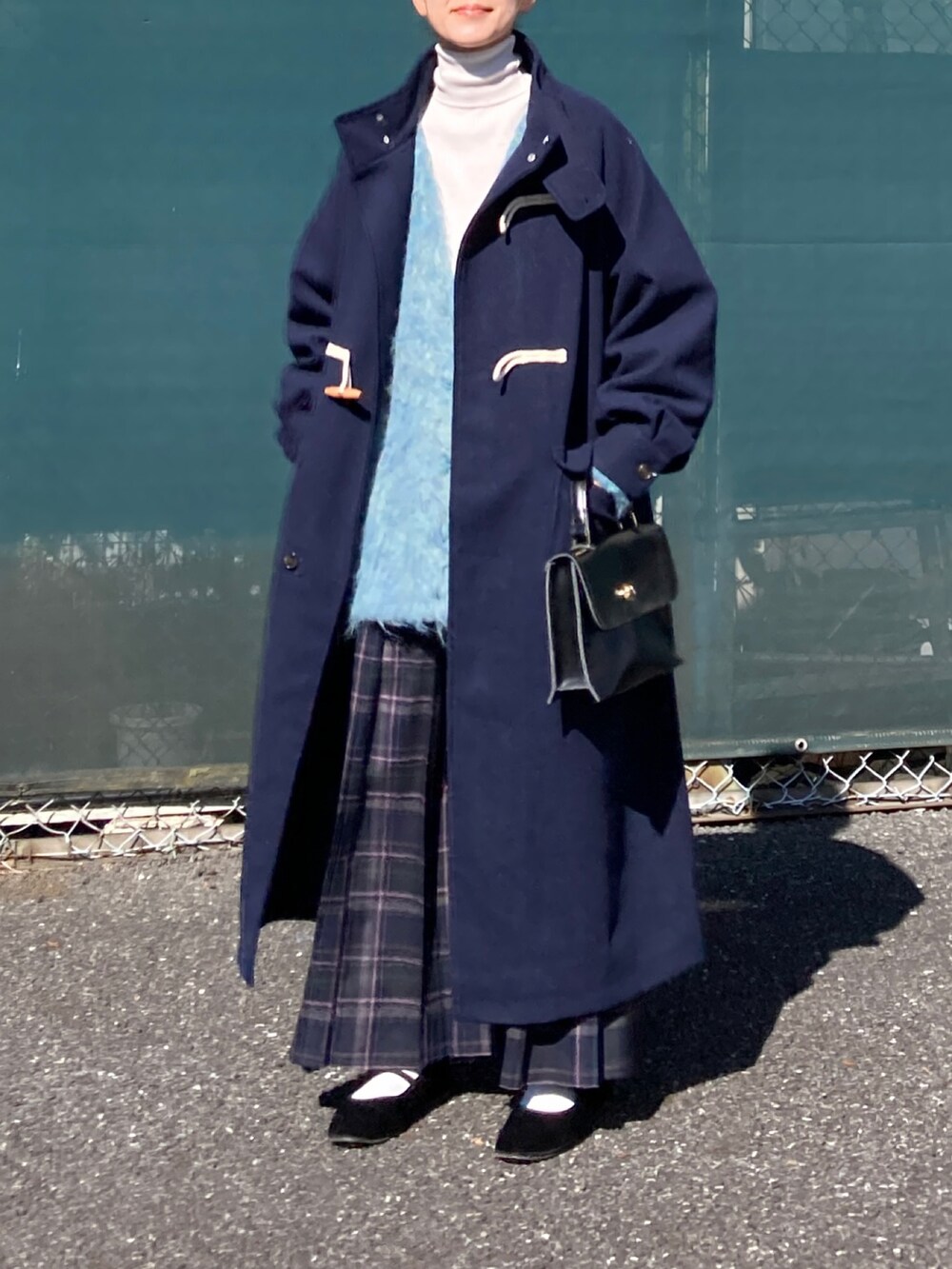 ブルー系のダッフルコート、ブルー系のカーディガン/ボレロ、ブルー系のスカートを着用したレディースの秋コーディネートの2枚目の写真