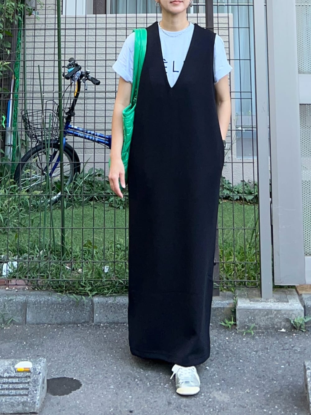 ブラック系のジャンパースカート、グリーン系のトートバッグ、その他のTシャツ/カットソーを着用したレディースの夏コーディネートの3枚目の写真