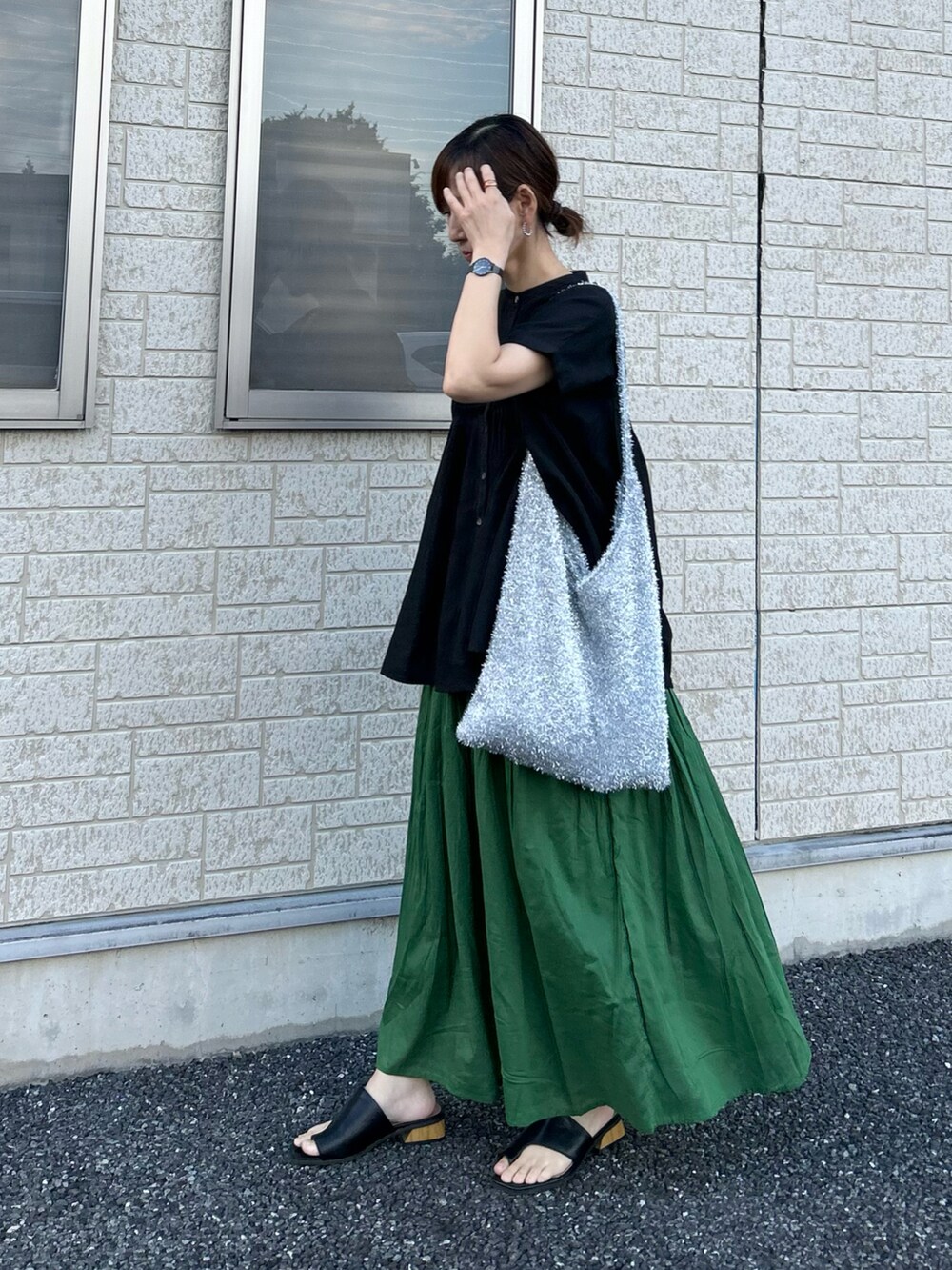 ブラック系のシャツ/ブラウス、グリーン系のスカート、シルバー系のトートバッグを着用したレディースの夏コーディネートの3枚目の写真