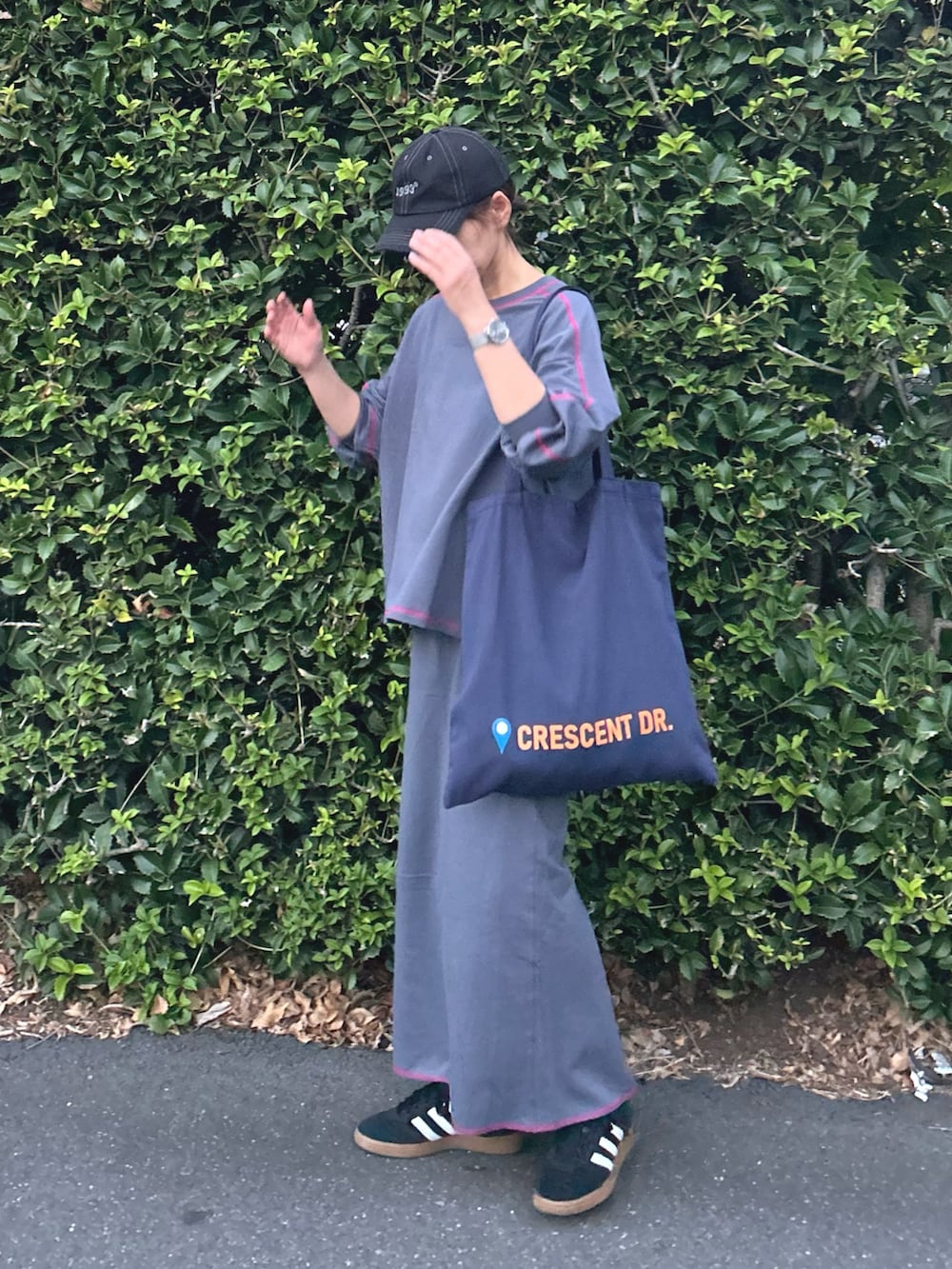 グレー系のTシャツ/カットソー、グレー系のスカート、ブルー系のトートバッグを着用したレディースの秋コーディネートの3枚目の写真