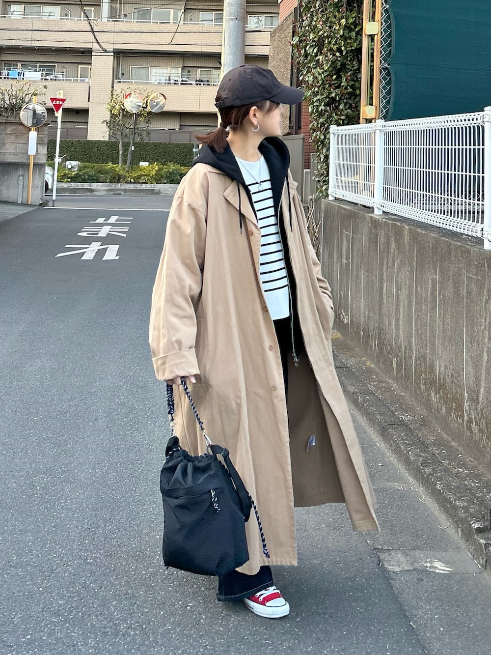 ホワイト系のニット/セーター、ブルー系のデニムパンツ、ブラック系のトートバッグを着用したレディースの春コーディネートの2枚目の写真