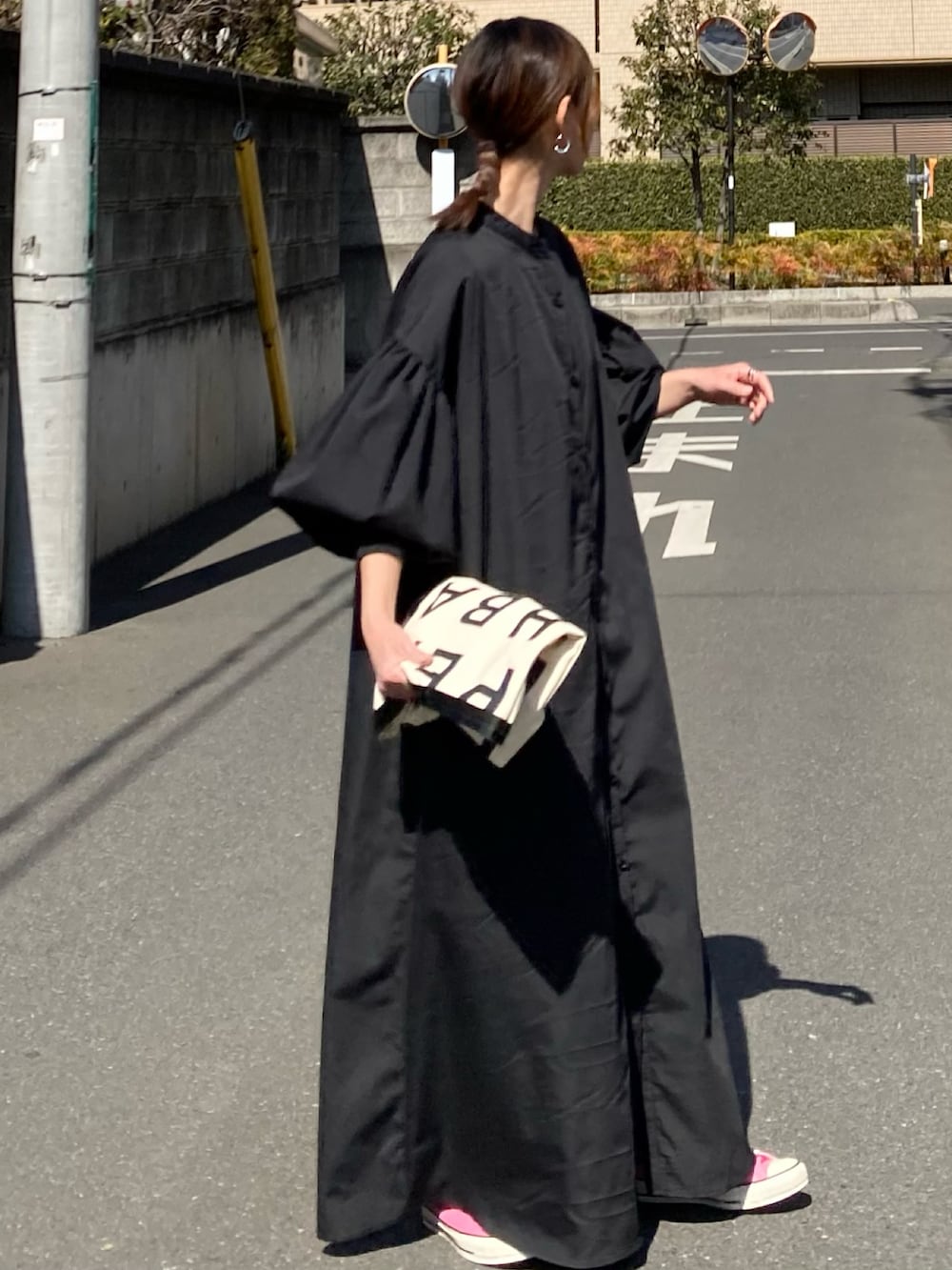 ブラック系のワンピース、ホワイト系のトートバッグ、レッド系のスニーカーを着用したレディースの春コーディネートの5枚目の写真