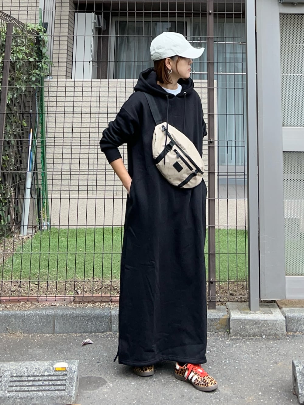 ブラック系のワンピース、その他のショルダーバッグ、ブラック系のスニーカーを着用したレディースの冬コーディネートの2枚目の写真