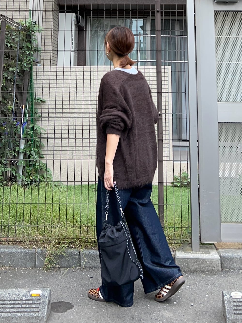 ホワイト系のTシャツ/カットソー、ブラウン系のカーディガン/ボレロ、ブルー系のデニムパンツを着用したレディースの秋コーディネートの4枚目の写真