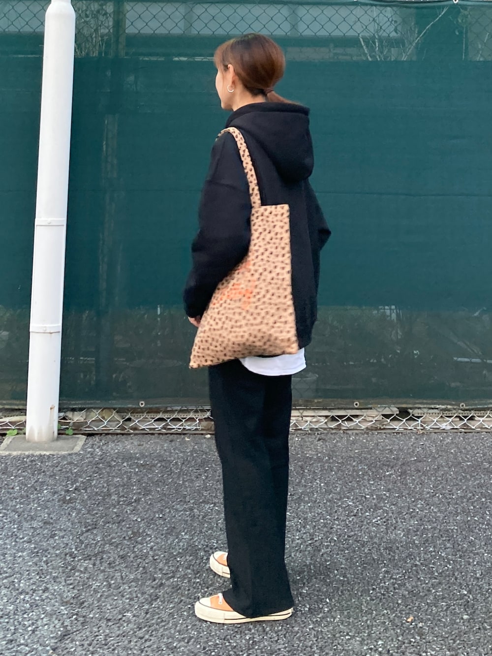 ブラック系のパーカー、ブラック系のその他パンツ、イエロー系のトートバッグを着用したレディースの秋コーディネートの5枚目の写真