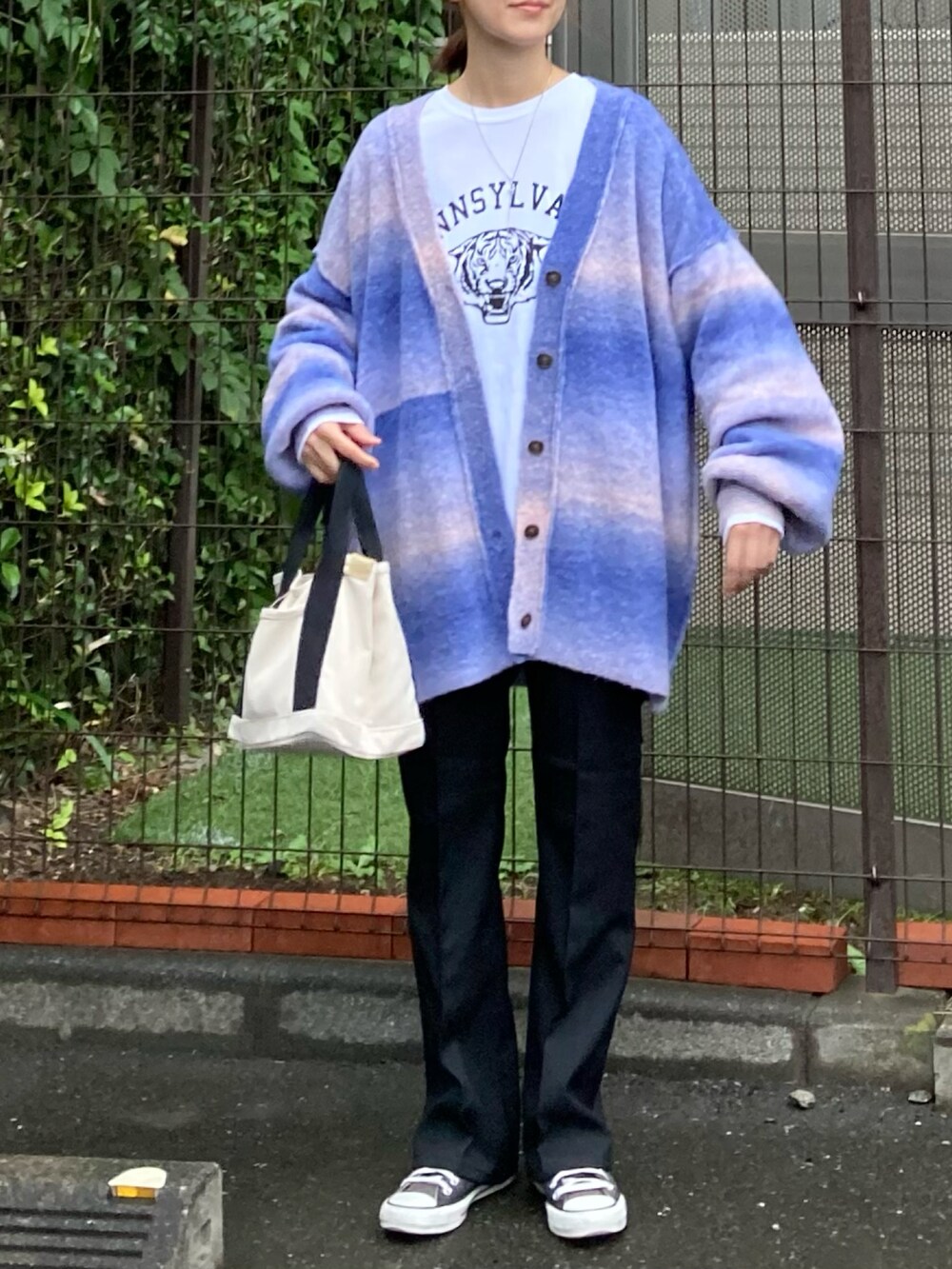 ブルー系のカーディガン/ボレロ、ホワイト系のTシャツ/カットソー、ブラック系のスラックスを着用したレディースの秋コーディネートの2枚目の写真