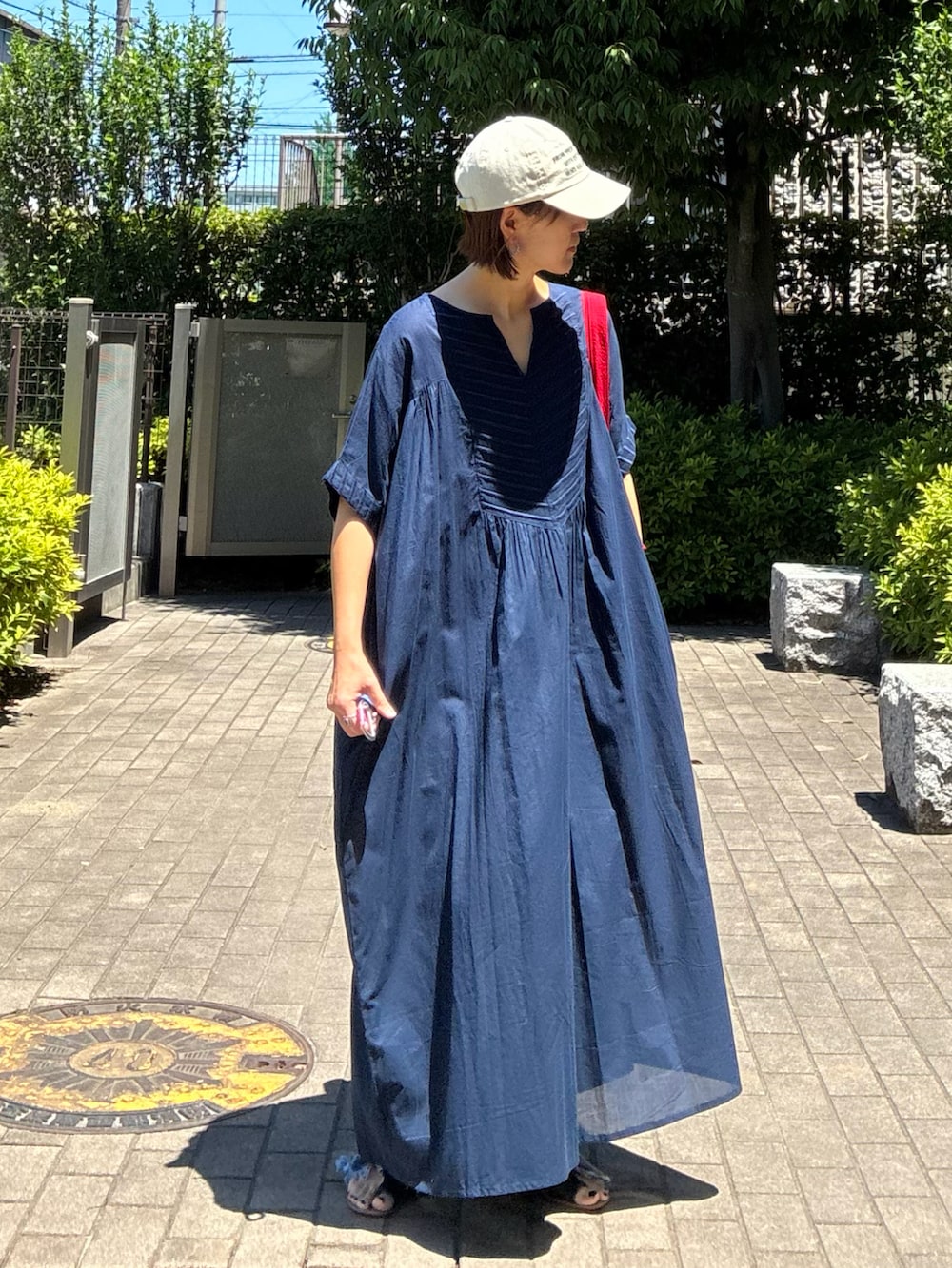 ブルー系のデニムパンツ、レッド系のトートバッグ、ブルー系のワンピースを着用したレディースの夏コーディネートの2枚目の写真