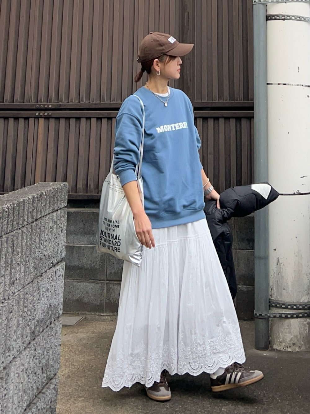 ブルー系のスウェット、ホワイト系のスカート、ブラック系のブルゾンを着用したレディースの冬コーディネートの4枚目の写真