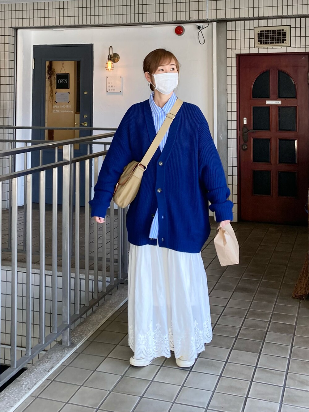 ブルー系のカーディガン/ボレロ、ブルー系のシャツ/ブラウス、ホワイト系のスカートを着用したレディースの春コーディネートの4枚目の写真