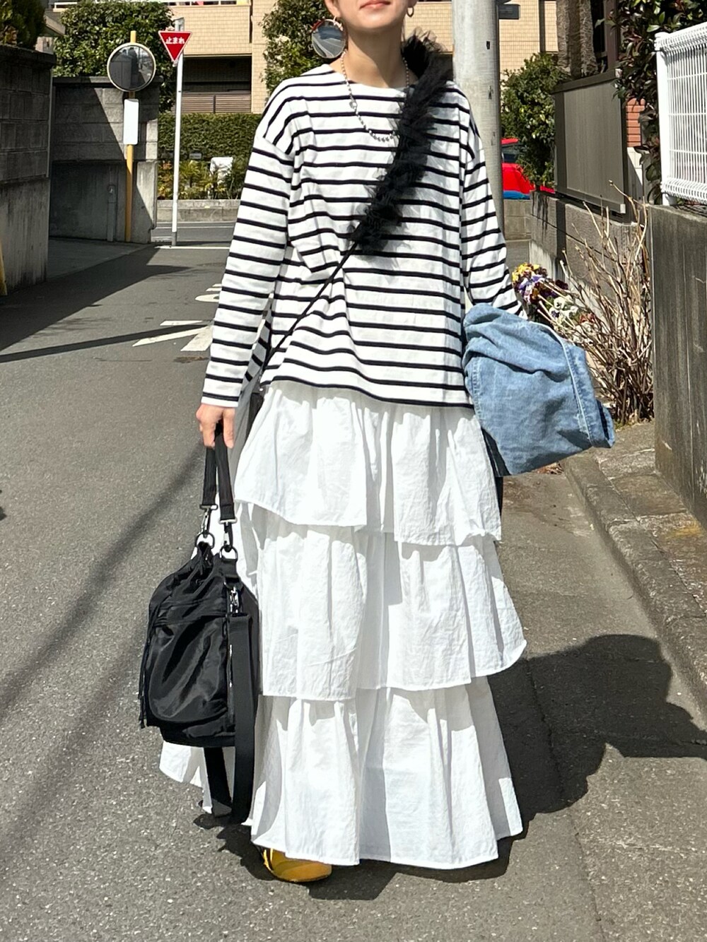 ホワイト系のTシャツ/カットソー、ホワイト系のスカート、ブラック系のショルダーバッグを着用したレディースの春コーディネートの2枚目の写真