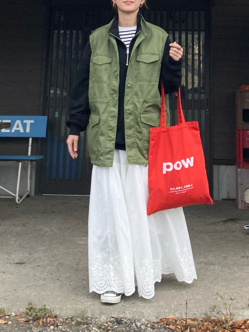 ブラック系のスウェット、グリーン系のベスト、ホワイト系のスカートを着用したレディースの冬コーディネートの5枚目の写真