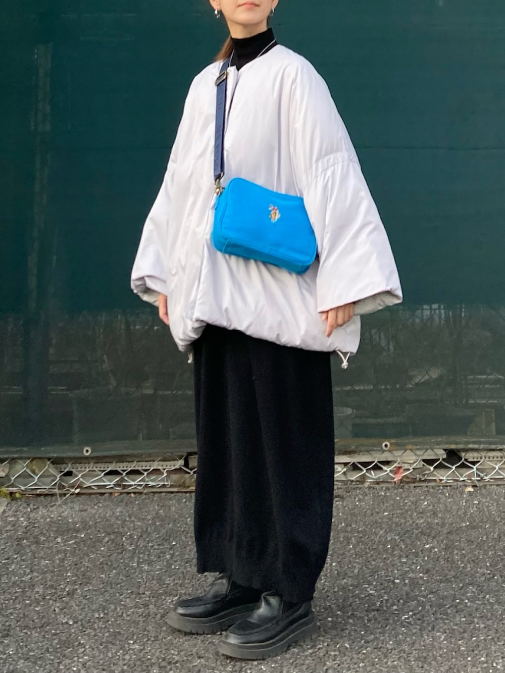 グレー系のその他アウター、ブラック系のワンピース、ブルー系のショルダーバッグを着用したレディースの冬コーディネートの4枚目の写真