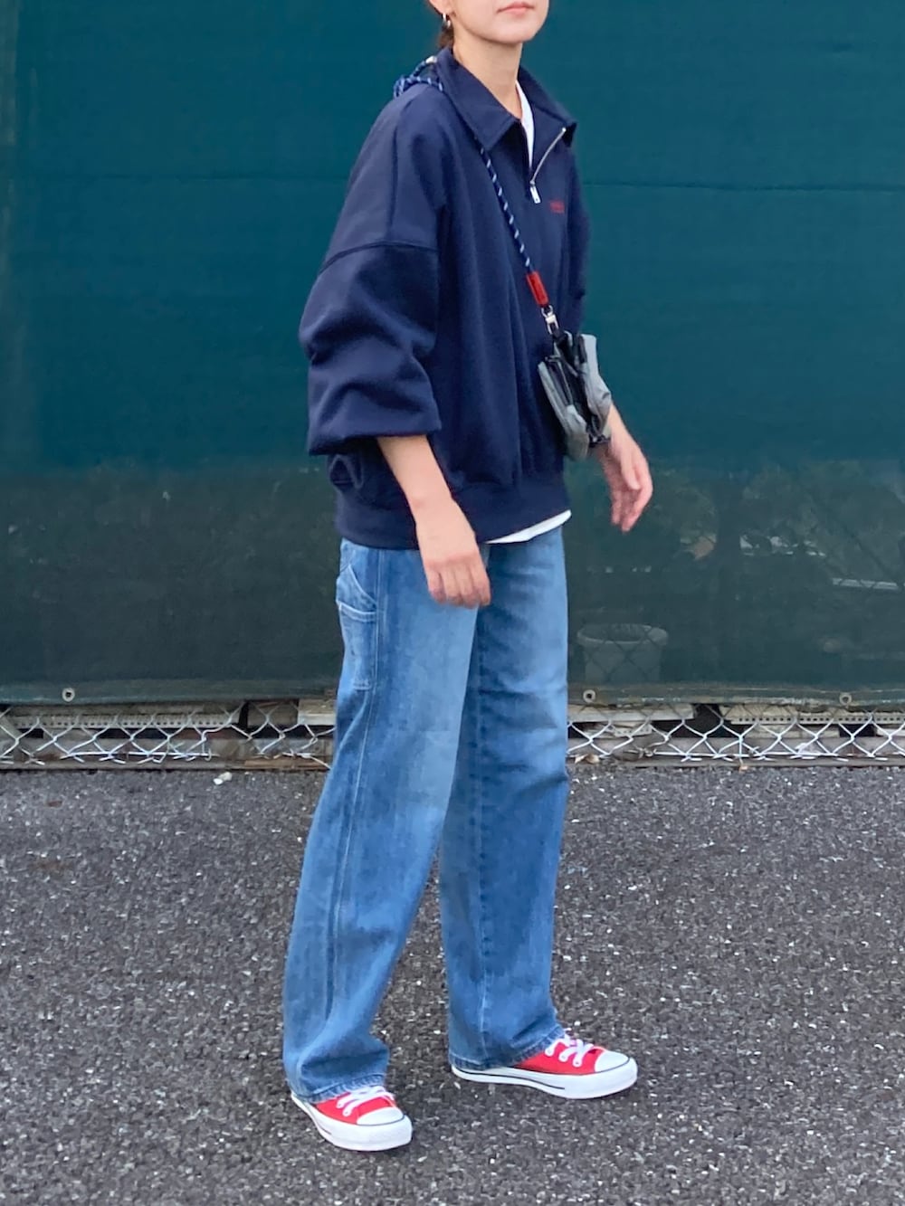 ブルー系のスウェット、ブルー系のデニムパンツ、グレー系のショルダーバッグを着用したレディースの秋コーディネートの2枚目の写真