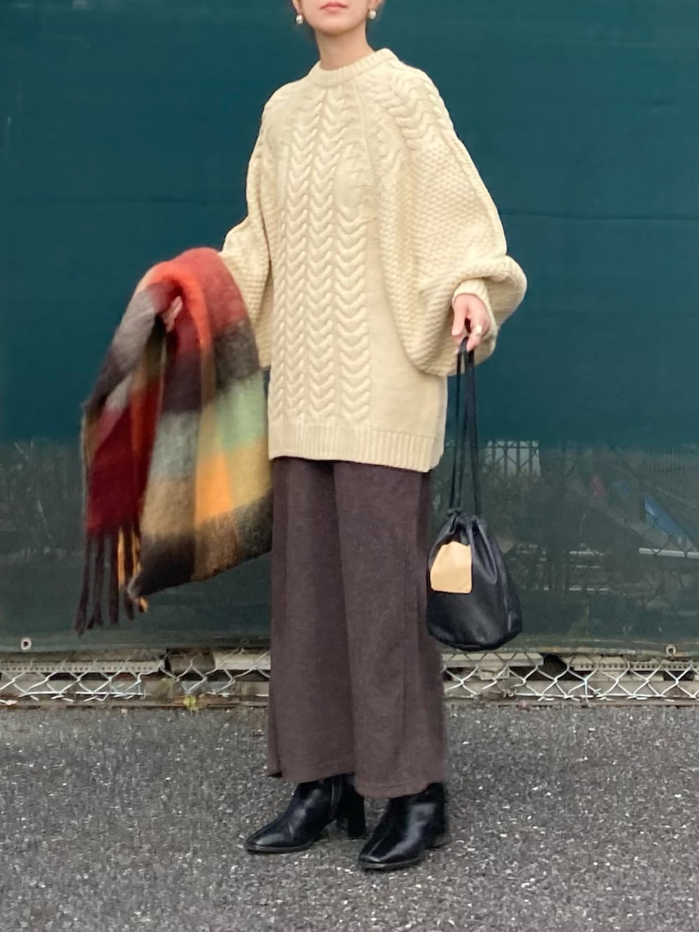 ホワイト系のニット/セーター、ブラウン系のスカート、ブラック系のハンドバッグを着用したレディースの冬コーディネートの4枚目の写真