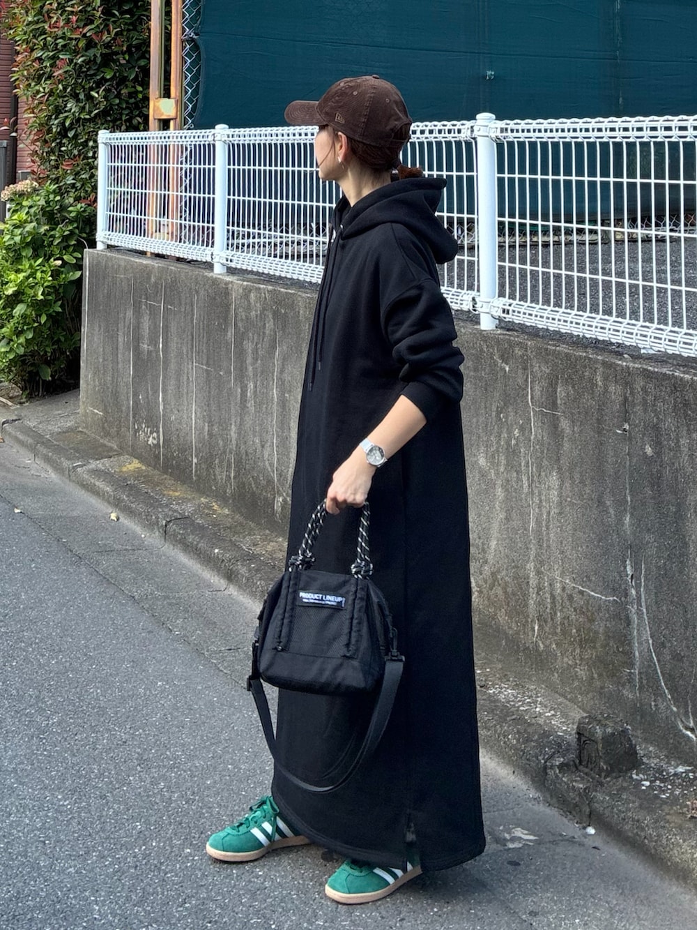 ブラック系のワンピース、ブラック系のトートバッグ、グリーン系のスニーカーを着用したレディースの夏コーディネートの3枚目の写真