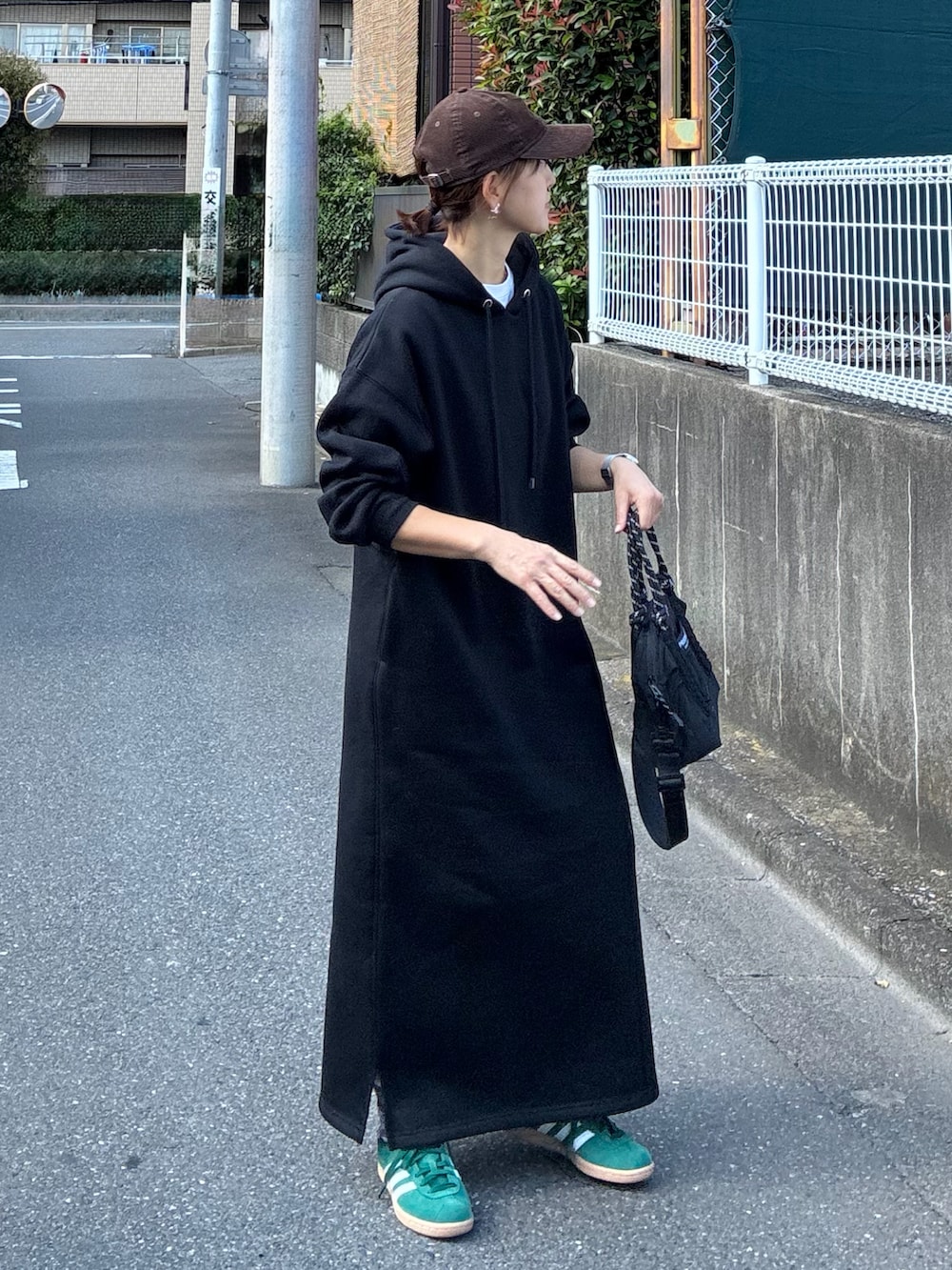 ブラック系のワンピース、ブラック系のトートバッグ、グリーン系のスニーカーを着用したレディースの夏コーディネートの5枚目の写真