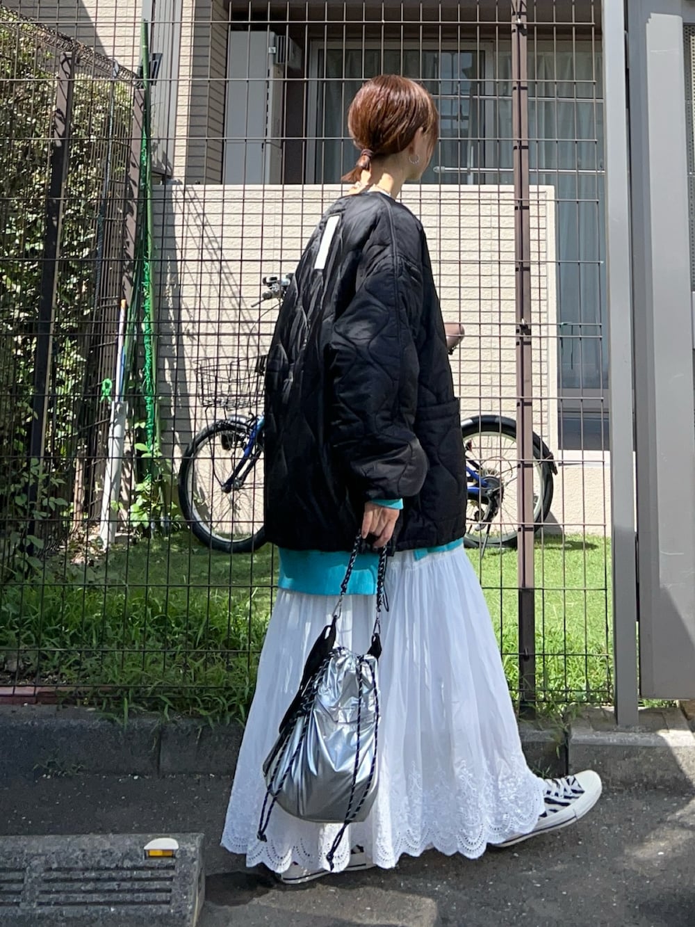 ホワイト系のスカート、シルバー系のトートバッグ、ブルー系のスウェットを着用したレディースの秋コーディネートの2枚目の写真