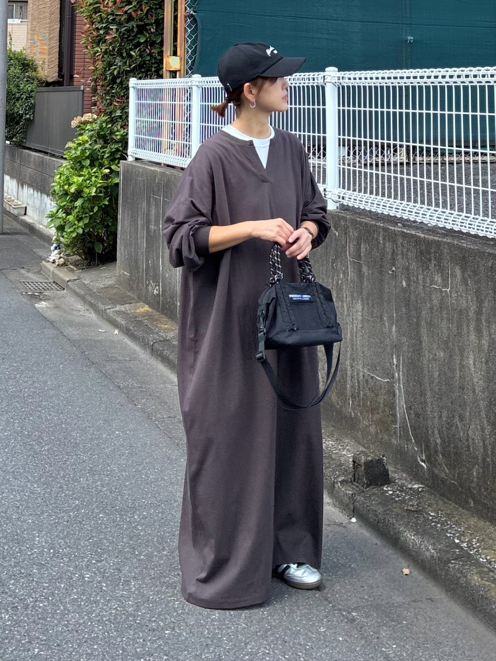 ブラウン系のワンピース、ブラック系のトートバッグ、ブラック系のキャップを着用したレディースの秋コーディネートの3枚目の写真