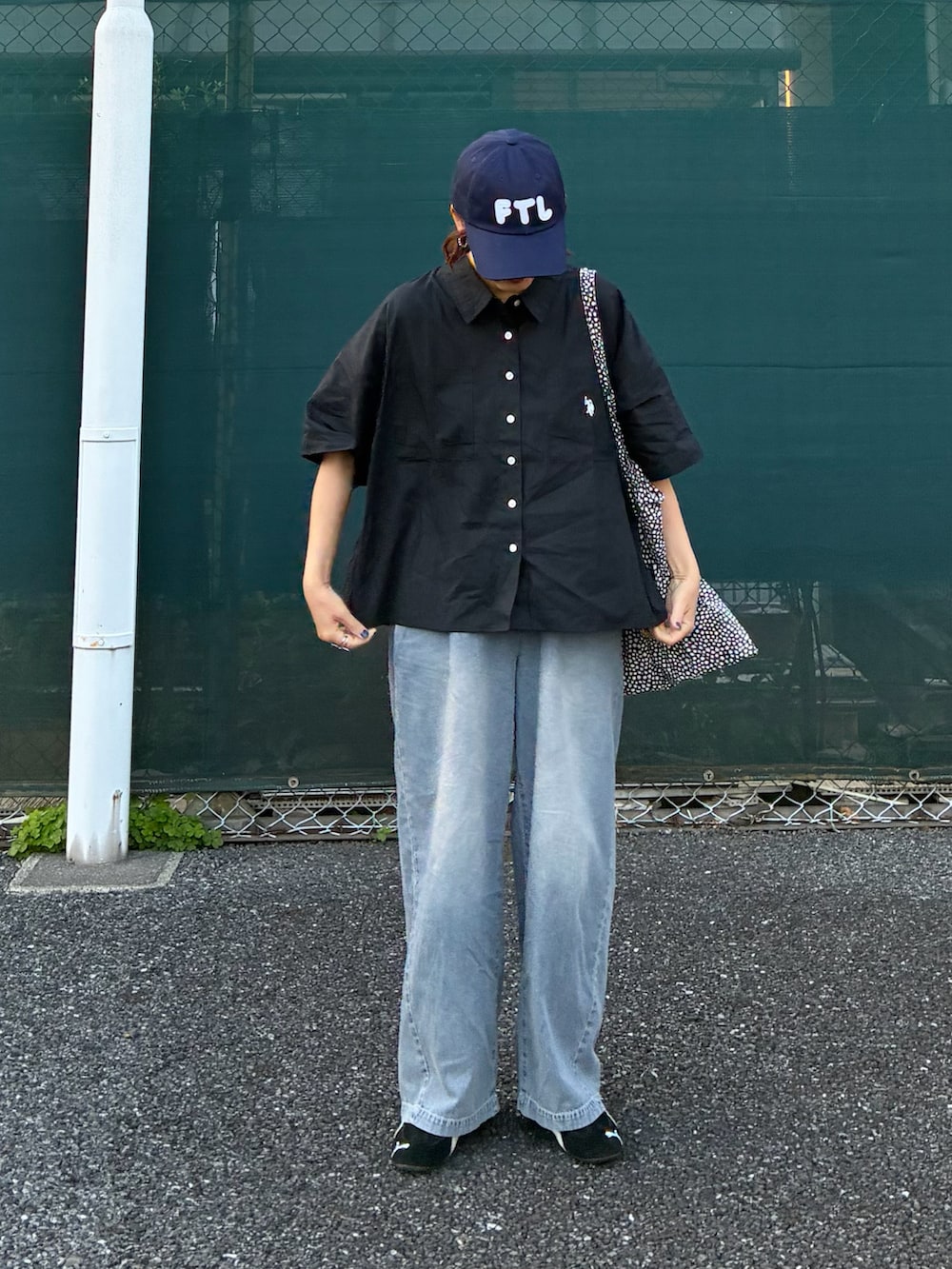 ブラック系のシャツ/ブラウス、ブルー系のデニムパンツ、ブルー系のキャップを着用したレディースの春コーディネートの2枚目の写真