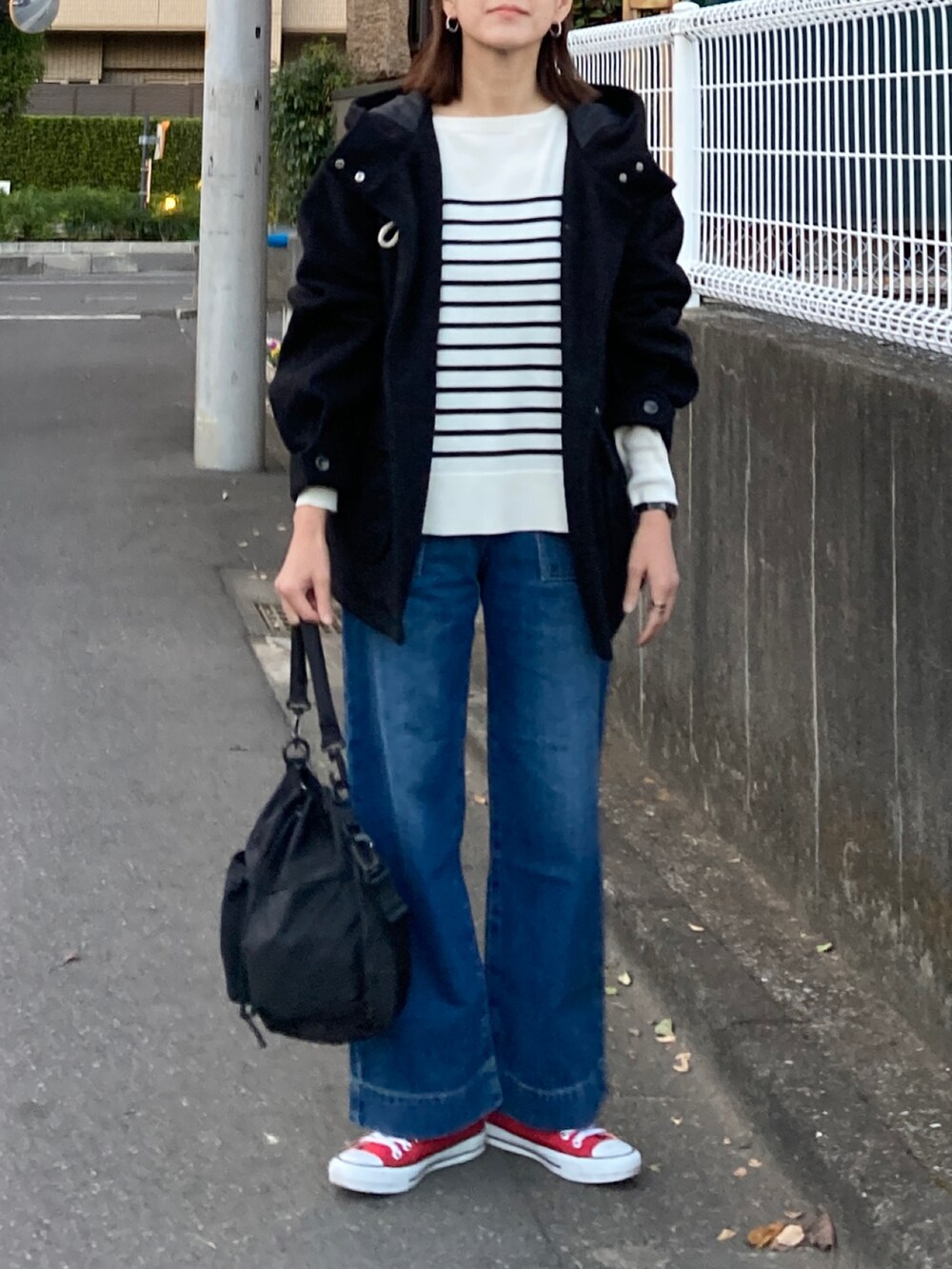 ブラック系のダッフルコート、ホワイト系のニット/セーター、ブラック系のショルダーバッグを着用したレディースの冬コーディネートの3枚目の写真