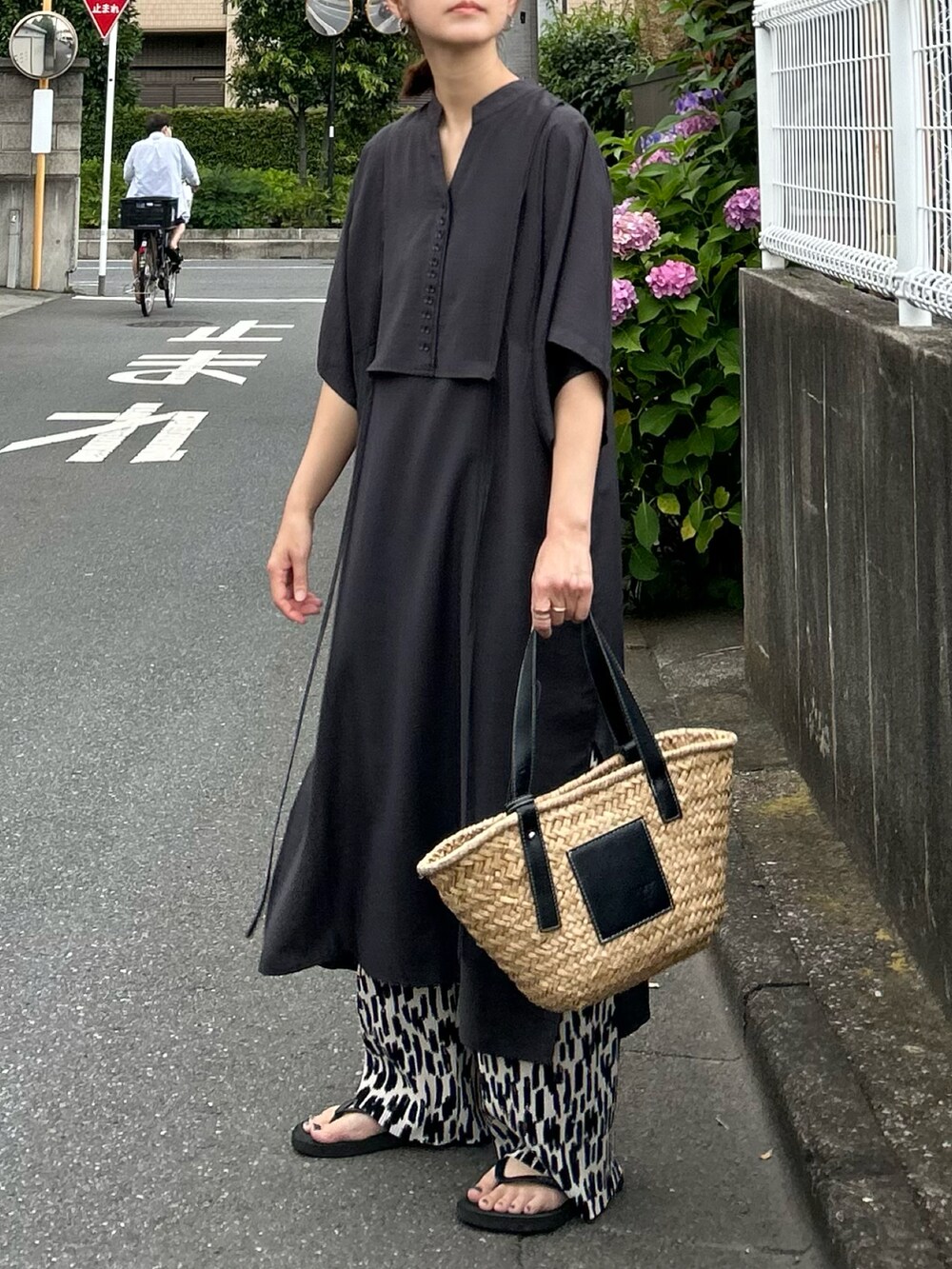 グレー系のシャツワンピース、ブラック系のかごバッグ、ホワイト系のその他パンツを着用したレディースの夏コーディネートの4枚目の写真