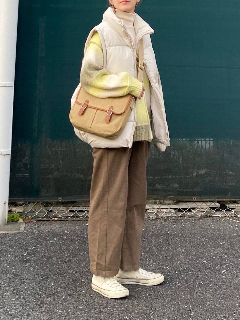イエロー系のカーディガン/ボレロ、ブラウン系のサロペット/オーバーオール、ベージュ系のショルダーバッグを着用したレディースの冬コーディネートの4枚目の写真