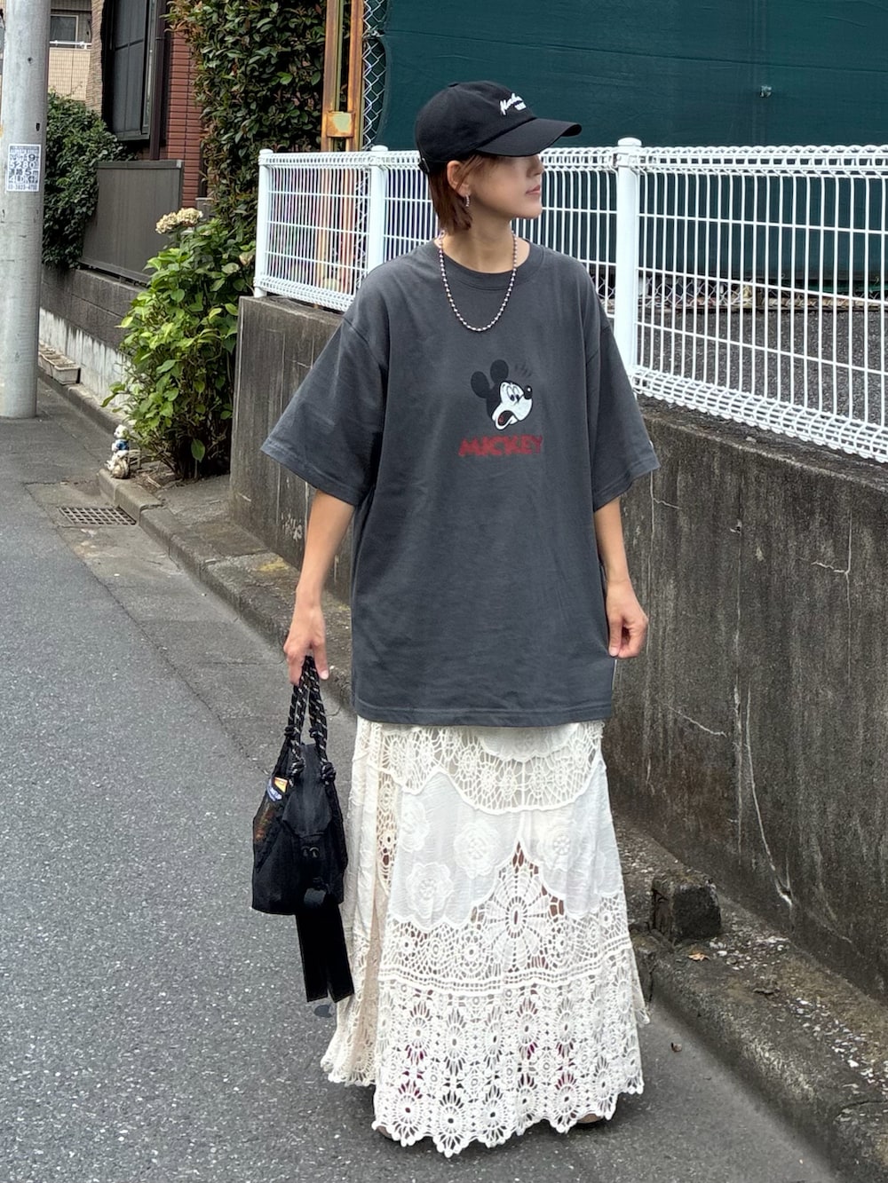 グレー系のTシャツ/カットソー、ホワイト系のスカート、ブラック系のトートバッグを着用したレディースの夏コーディネートの2枚目の写真