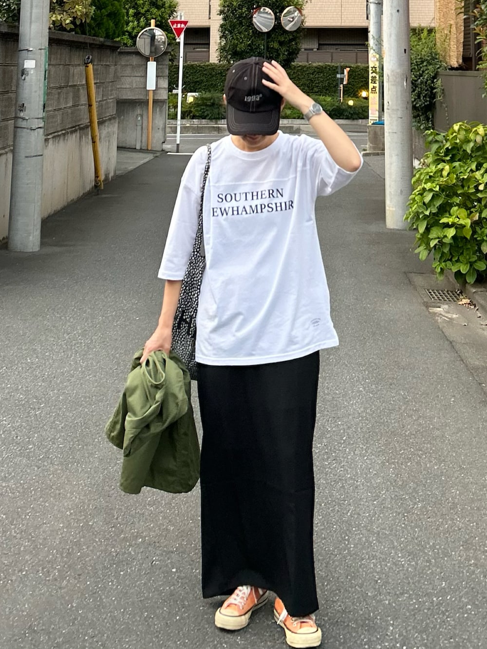 ホワイト系のTシャツ/カットソー、グリーン系のベスト、ブラック系のスカートを着用したレディースの夏コーディネートの4枚目の写真