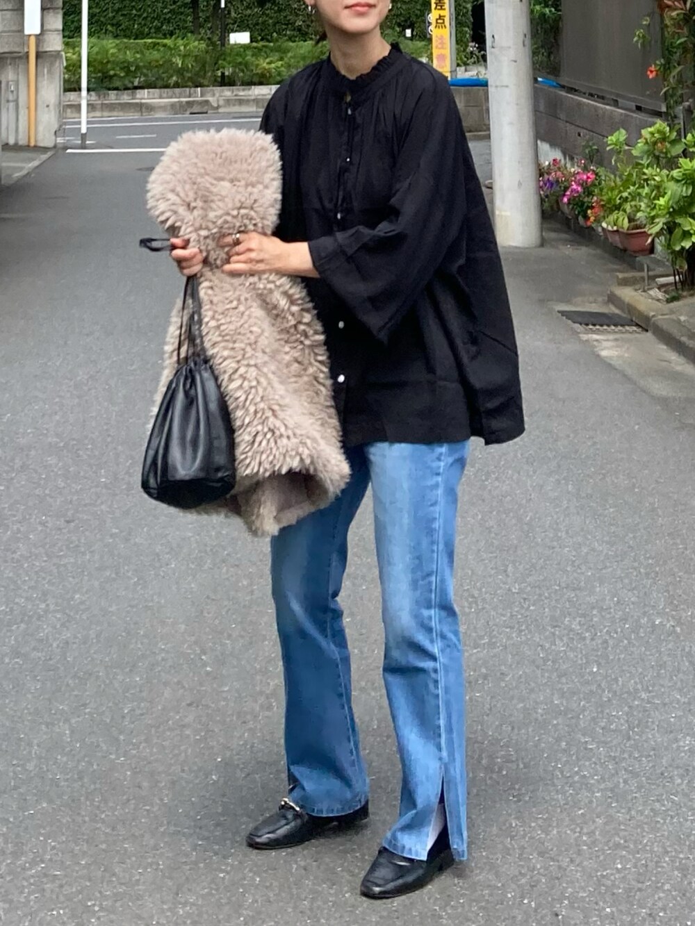 ブラック系のシャツ/ブラウス、ブルー系のデニムパンツ、ベージュ系のベストを着用したレディースの秋コーディネートの2枚目の写真