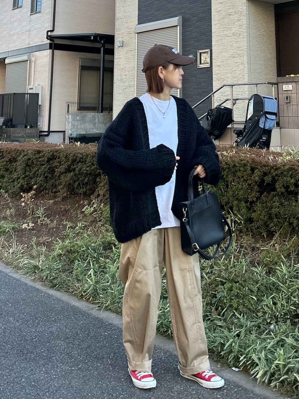 ベージュ系のチノパンツ、ブラック系のショルダーバッグ、レッド系のスニーカーを着用したレディースの冬コーディネートの3枚目の写真