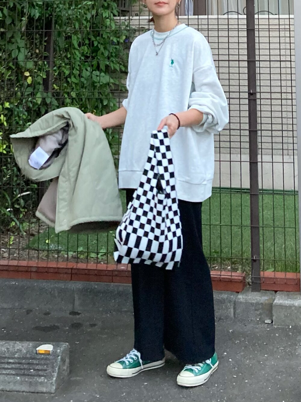 ベージュ系のスウェット、ブラック系のスカート、グリーン系のダウンジャケット/コートを着用したレディースの秋コーディネートの3枚目の写真