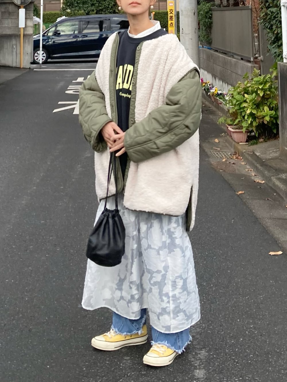 グリーン系のブルゾン、ブラック系のスウェット、ホワイト系のワンピースを着用したレディースの冬コーディネートの5枚目の写真