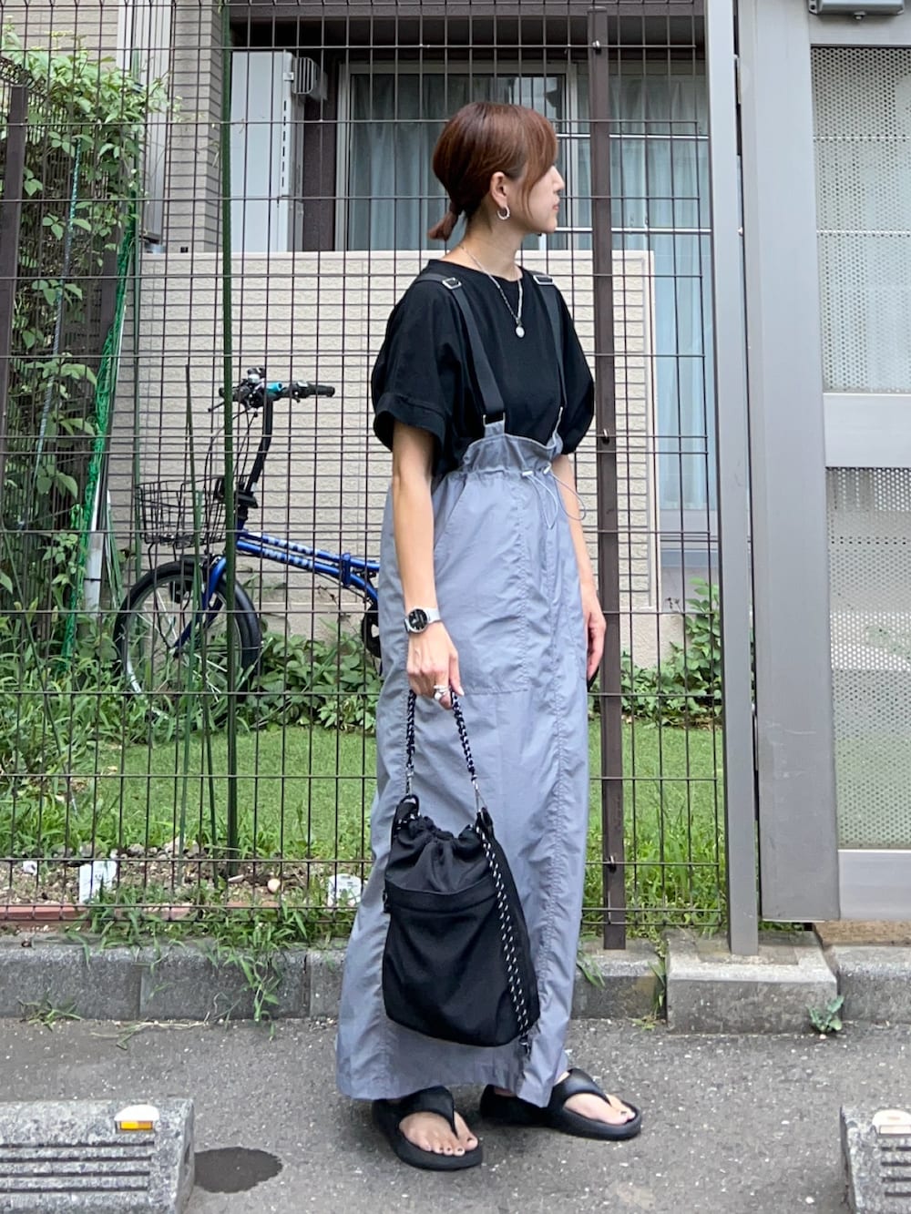 グレー系のジャンパースカート、ブラック系のトートバッグ、ブラック系のTシャツ/カットソーを着用したレディースの夏コーディネートの2枚目の写真