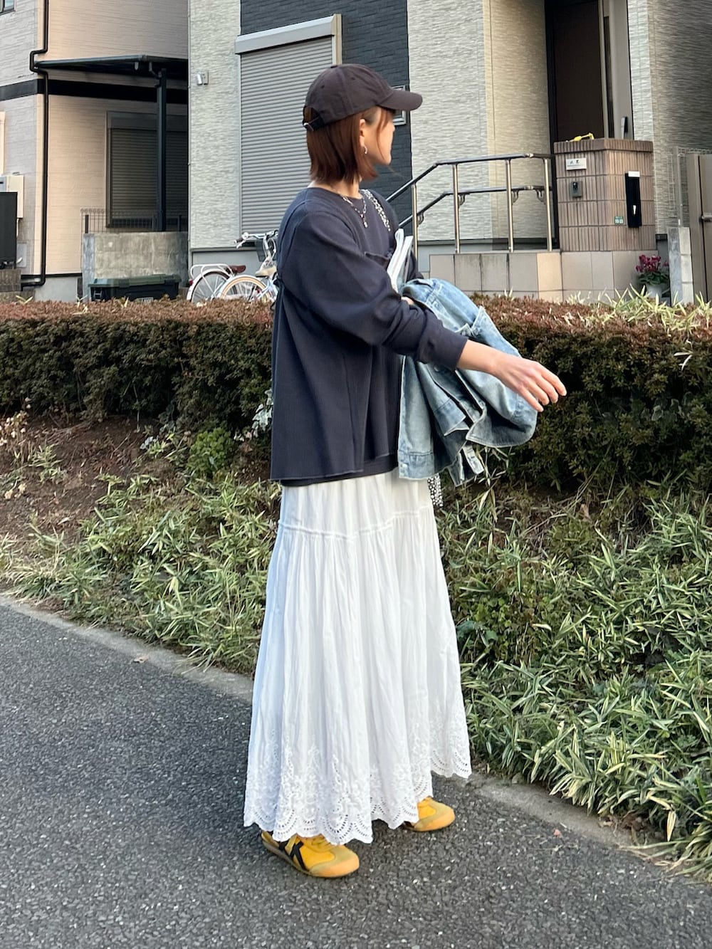 ホワイト系のスカート、グレー系のアンサンブル、イエロー系のスニーカーを着用したレディースの冬コーディネートの3枚目の写真