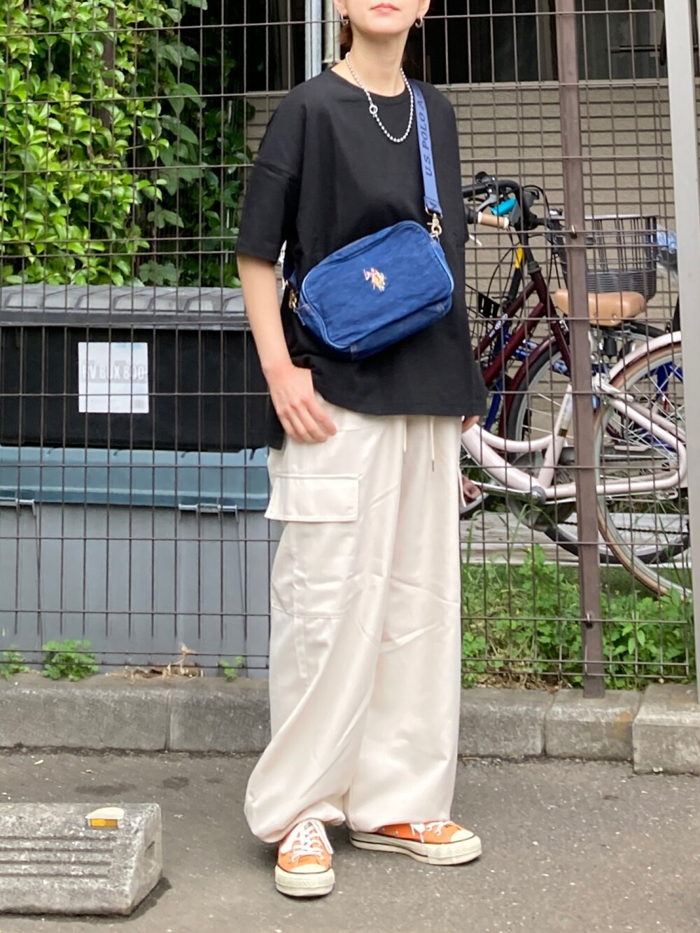 ブラック系のTシャツ/カットソー、ホワイト系のその他パンツ、ブルー系のショルダーバッグを着用したレディースの春コーディネートの2枚目の写真