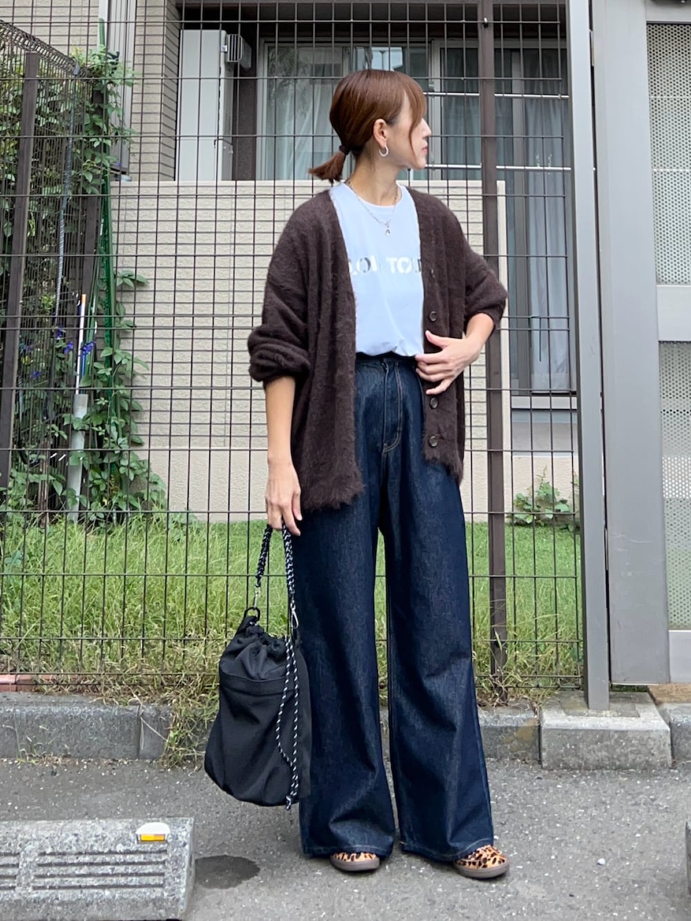 ホワイト系のTシャツ/カットソー、ブラウン系のカーディガン/ボレロ、ブルー系のデニムパンツを着用したレディースの秋コーディネートの2枚目の写真