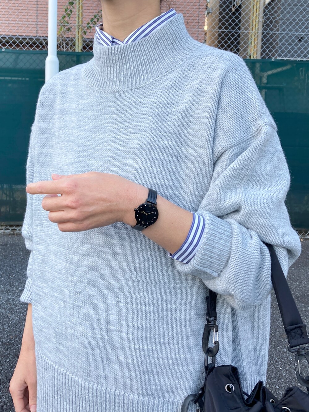 ブラック系のダウンベスト、グレー系のニット/セーター、ブルー系のシャツ/ブラウスを着用したレディースの冬コーディネートの3枚目の写真