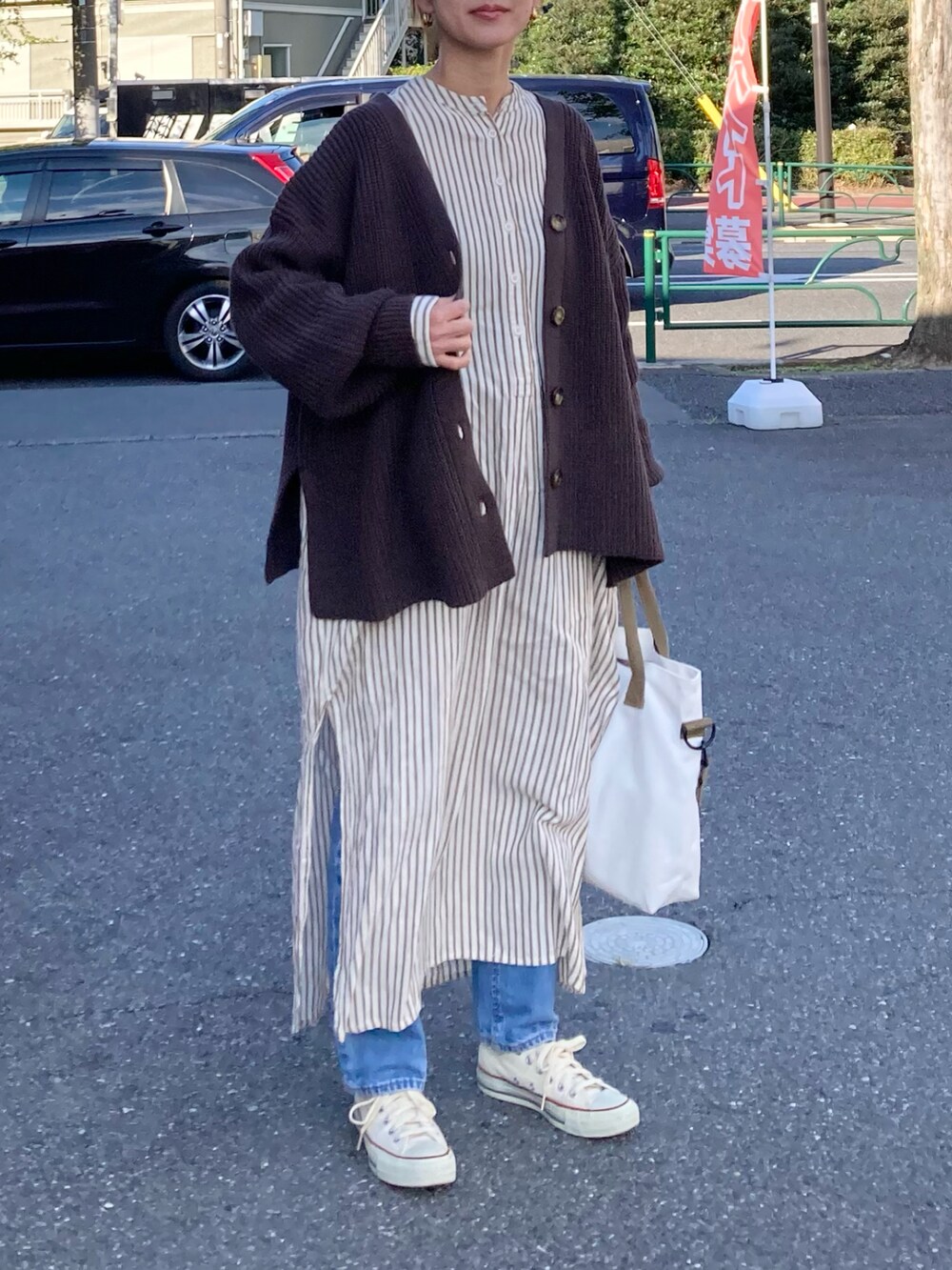 ブラウン系のカーディガン/ボレロ、ホワイト系のトートバッグ、ホワイト系のワンピースを着用したレディースの秋コーディネートの2枚目の写真