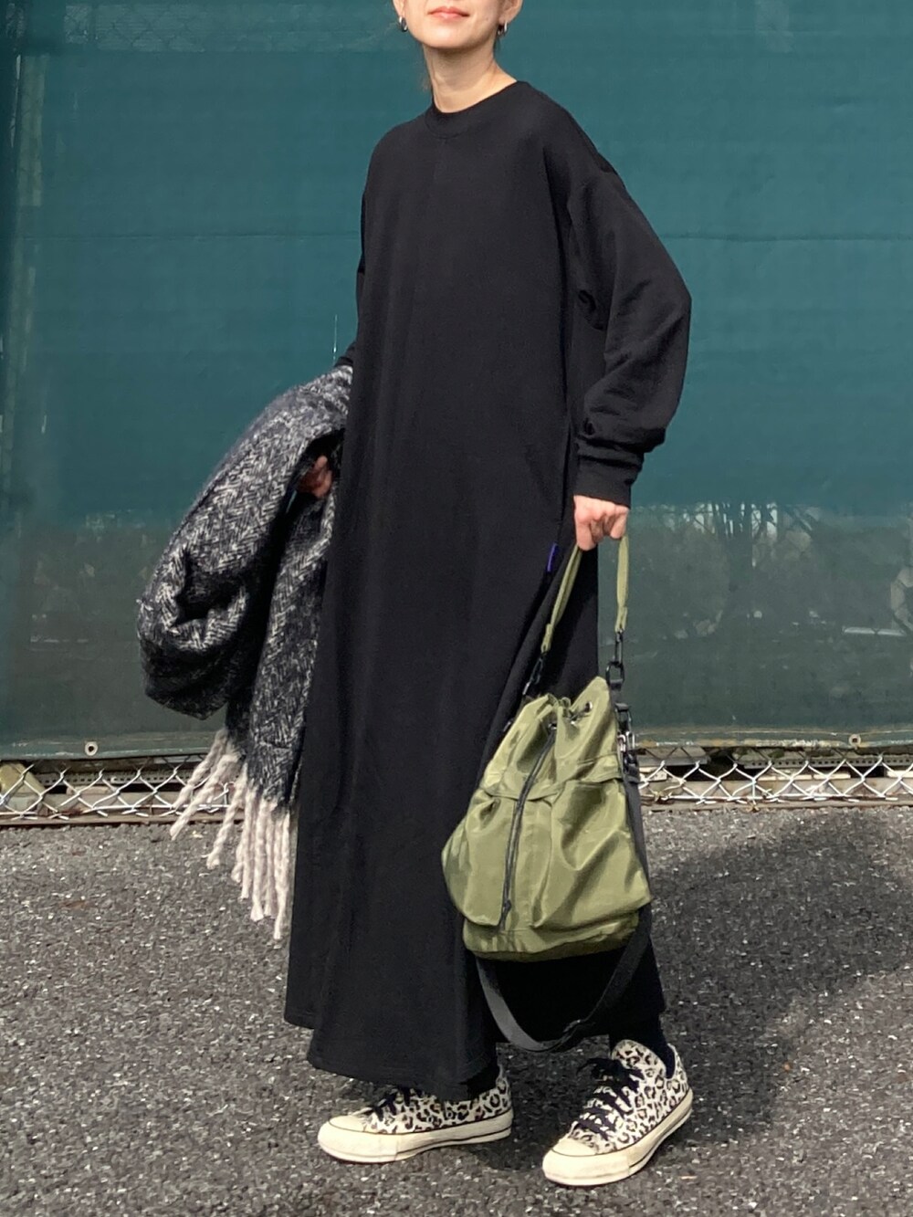 ブラック系のワンピース、グリーン系のショルダーバッグ、ブラック系のストール/ショールを着用したレディースの秋コーディネートの2枚目の写真