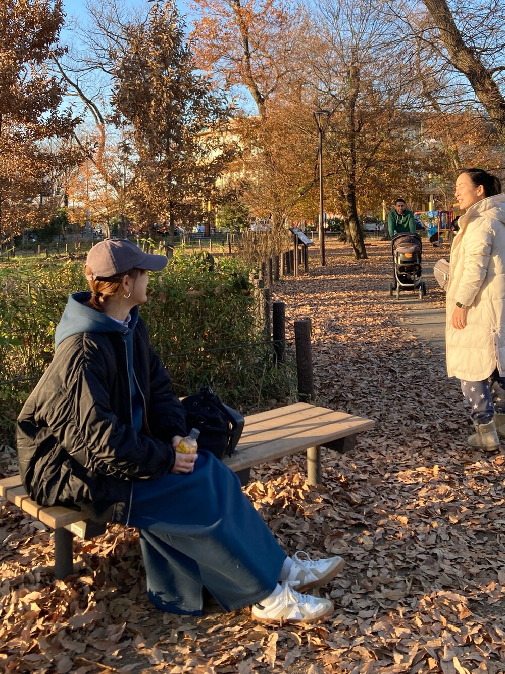 ブラック系のブルゾン、ブルー系のワンピース、ブラック系のショルダーバッグを着用したレディースの冬コーディネートの2枚目の写真