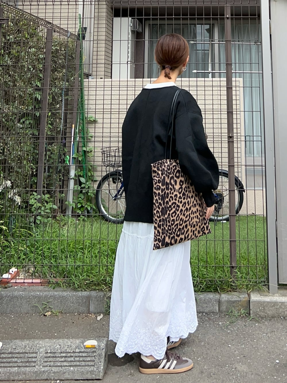 ブラック系のニット/セーター、ホワイト系のTシャツ/カットソー、ホワイト系のスカートを着用したレディースの秋コーディネートの3枚目の写真