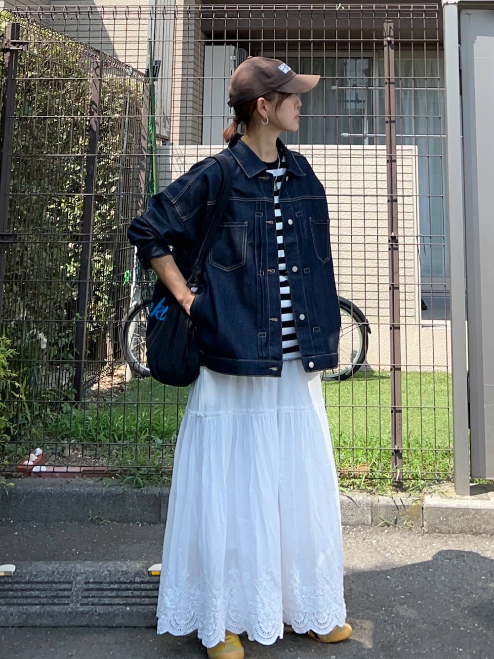 ブラック系のTシャツ/カットソー、ブルー系のデニムジャケット、ブラック系のトートバッグを着用したレディースの秋コーディネートの2枚目の写真