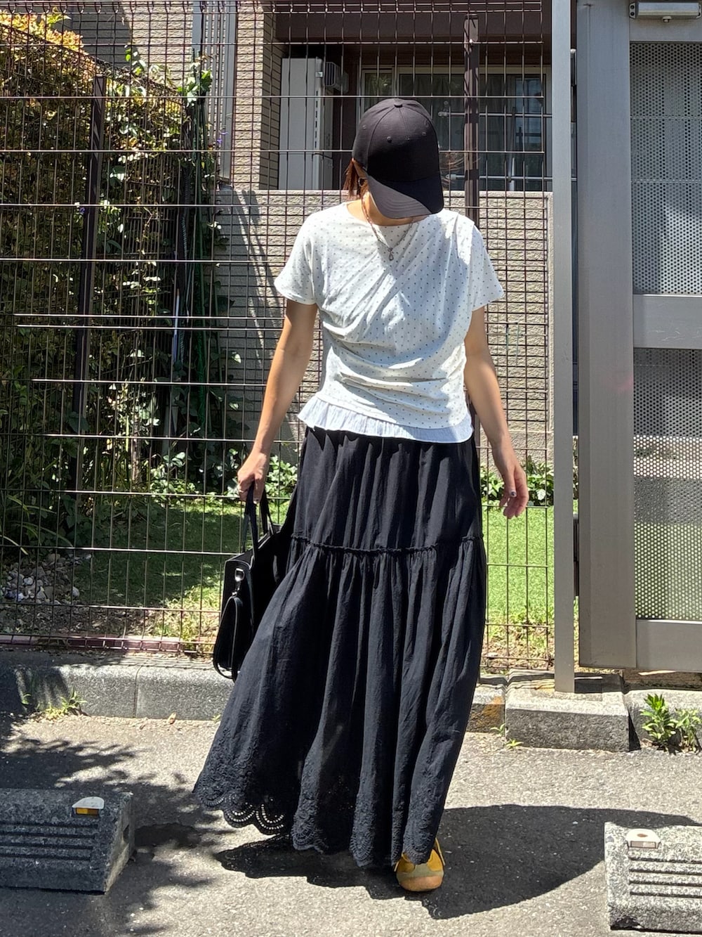 ホワイト系のTシャツ/カットソー、ブラック系のスカートを着用したレディースの夏コーディネートの3枚目の写真