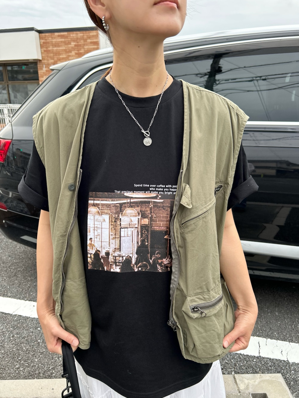 ブラック系のTシャツ/カットソー、ホワイト系のスカート、ブラック系のショルダーバッグを着用したレディースの夏コーディネートの5枚目の写真