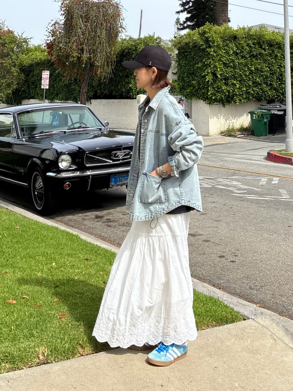 ブルー系のデニムジャケット、シルバー系のトートバッグ、ホワイト系のスカートを着用したレディースの春コーディネートの4枚目の写真