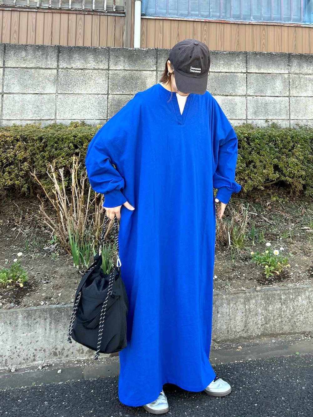 ブラック系のトートバッグ、ブルー系のワンピース、シルバー系のスニーカーを着用したレディースの冬コーディネートの4枚目の写真