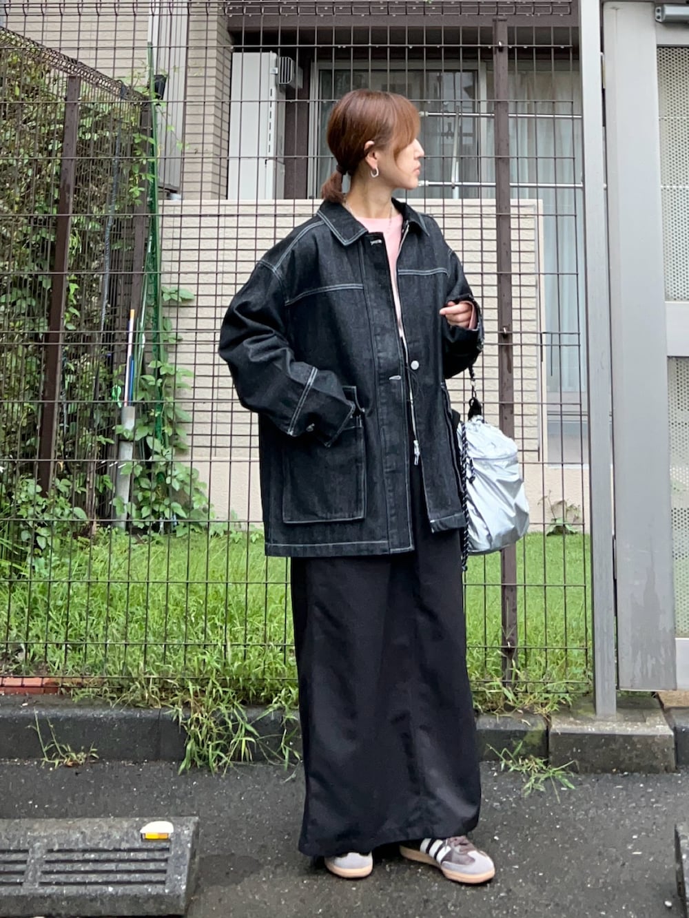 オレンジ系のTシャツ/カットソー、ブラック系のデニムジャケット、シルバー系のトートバッグを着用したレディースの秋コーディネートの3枚目の写真