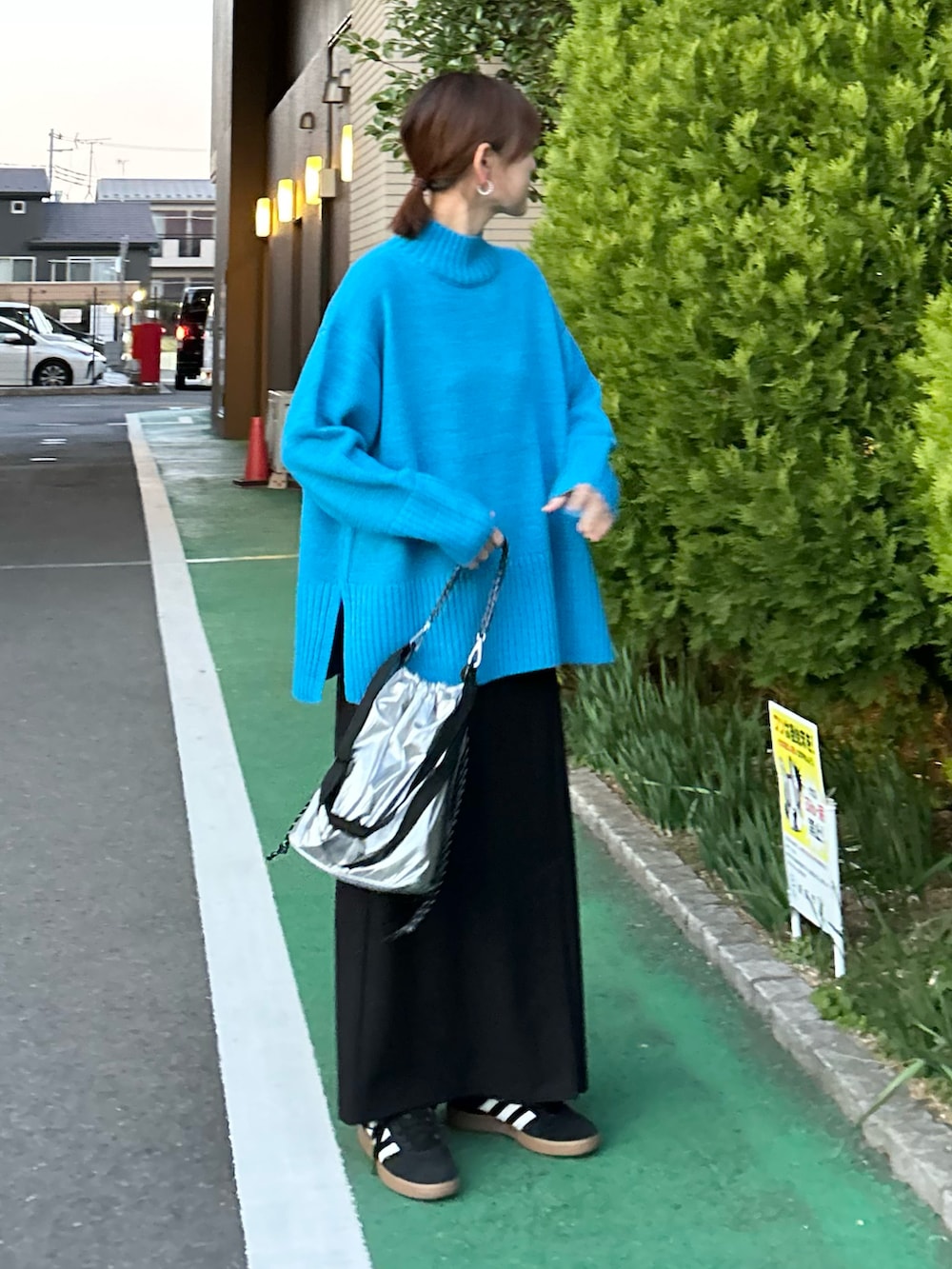 ブルー系のニット/セーター、ブラック系のスカート、シルバー系のトートバッグを着用したレディースの冬コーディネートの3枚目の写真